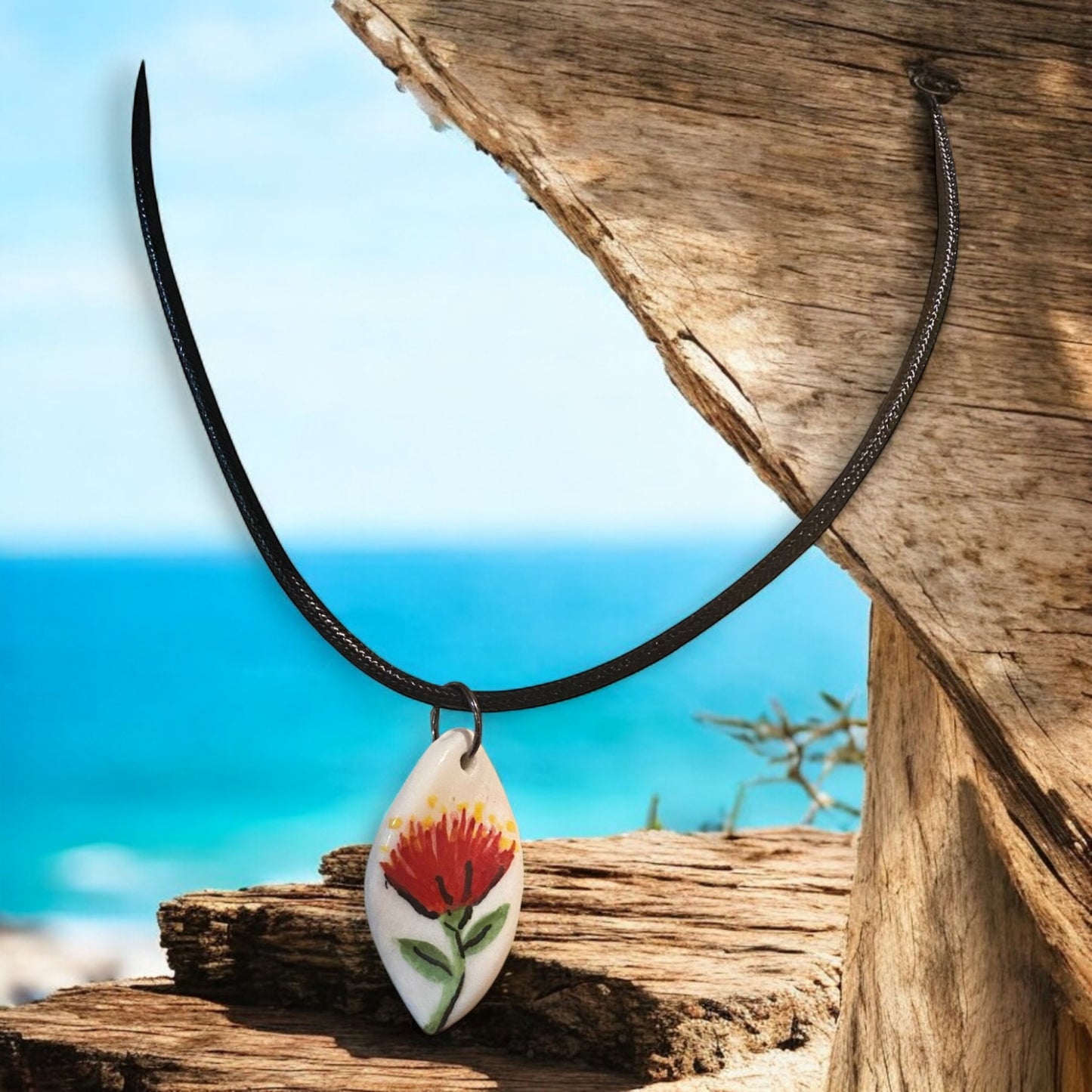 Necklace with a Pohutuukawa flower pendant on a white background