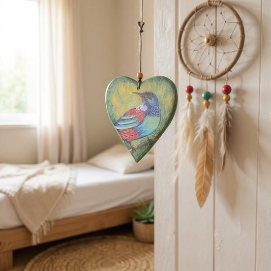 Decorative heart-shaped hanging with Tui Heart design and  on a wall in a bedroom.