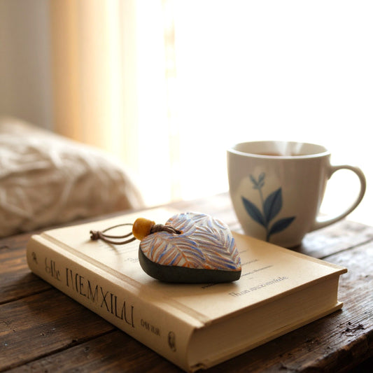 Ceramic Heart with a patterned design of New Zealand Ferns on a on a table.
