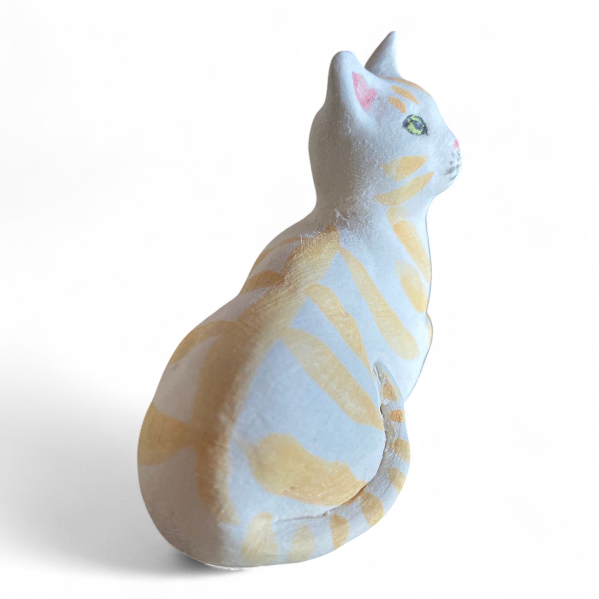 Porcelain Cat figurine with yellow and white stripes on a white background