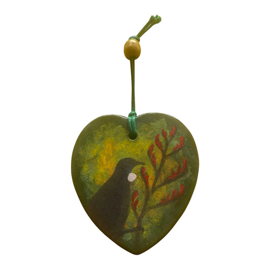 Heart-shaped ornament with a Tui bird design on a white background