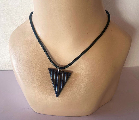 Necklace with a black triangle pendant on a mannequin neck against a white background