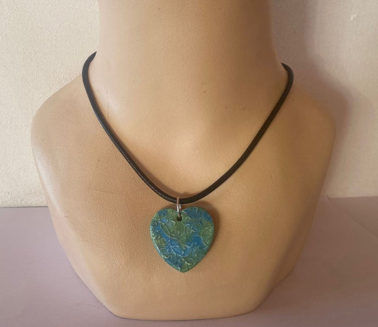 Necklace with a turquoise heart-shaped pendant on a mannequin neck.