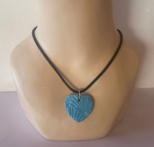 Necklace with a blue heart-shaped pendant on a mannequin bust.