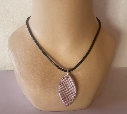 Necklace with a pink leaf-shaped pendant on a mannequin bust.