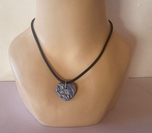 Necklace with a heart-shaped pendant on a mannequin bust against a neutral background