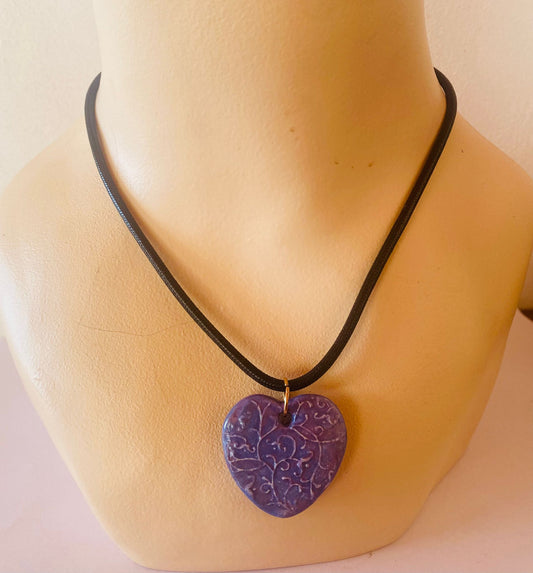 Necklace with a purple heart-shaped pendant on a mannequin