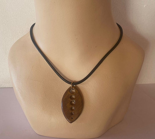 Necklace with a pendant on a mannequin neck against a plain background