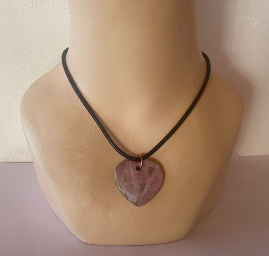 Necklace with a heart-shaped pink pendant on a mannequin neck.