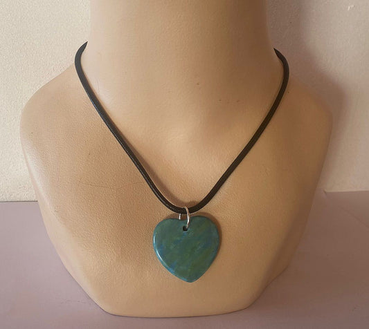 Necklace with a turquoise heart-shaped pendant on a mannequin bust.