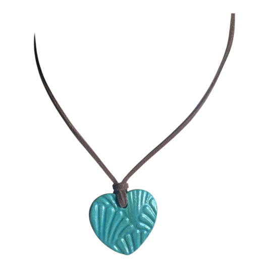 Turquoise heart-shaped pendant on a brown cord against a white background