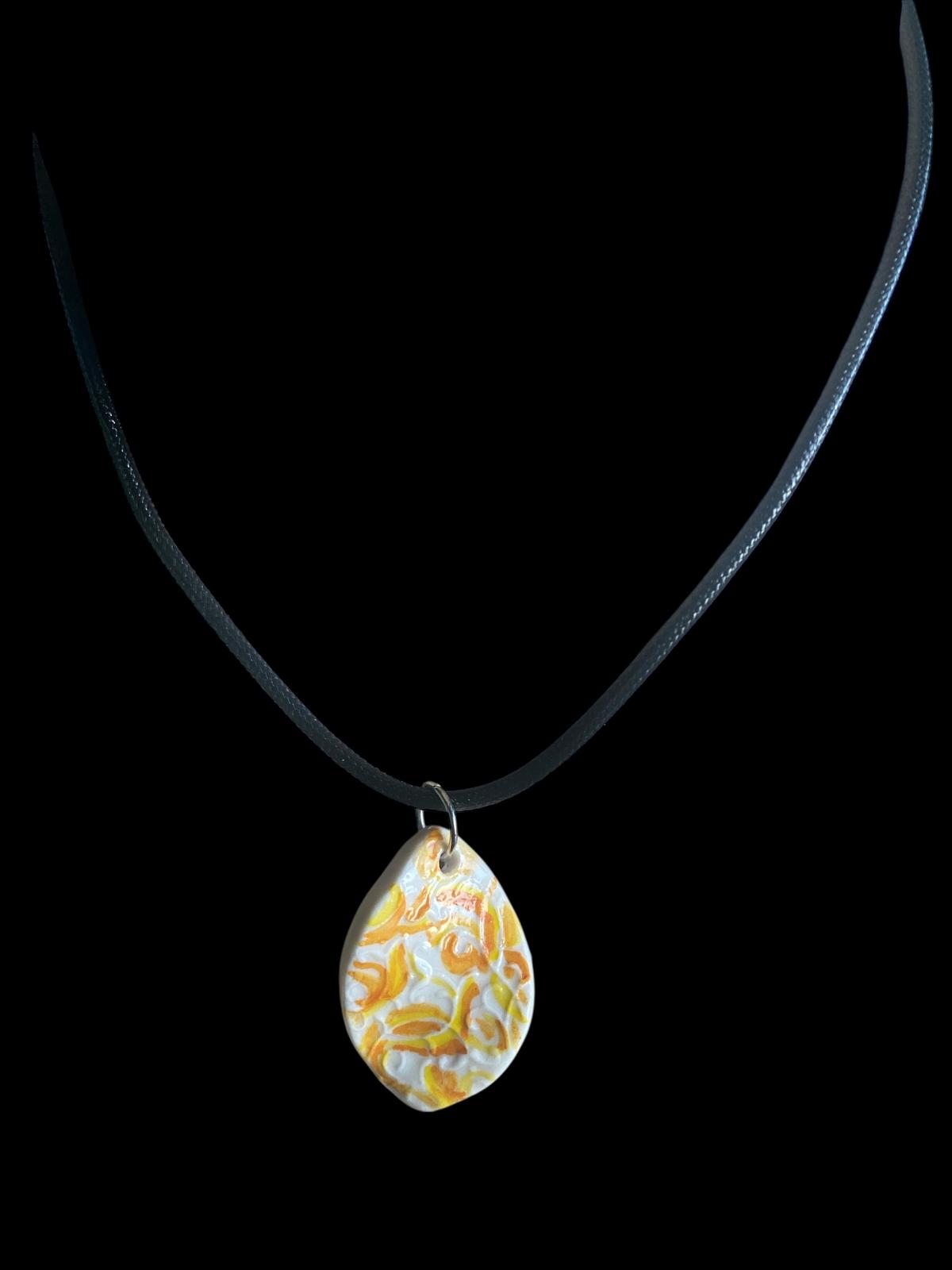 Necklace with a teardrop-shaped pendant on a black background