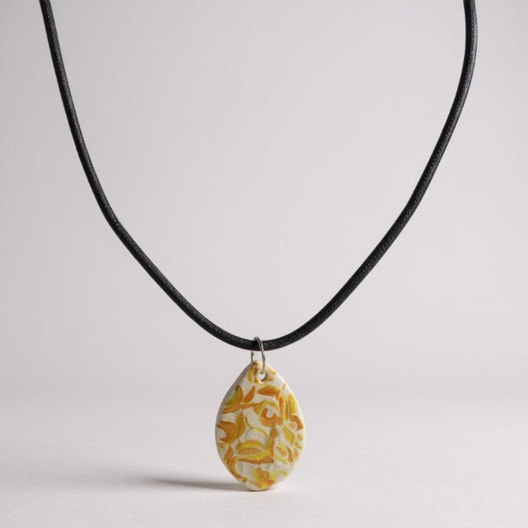 Necklace with a yellow floral pendant on a light gray background