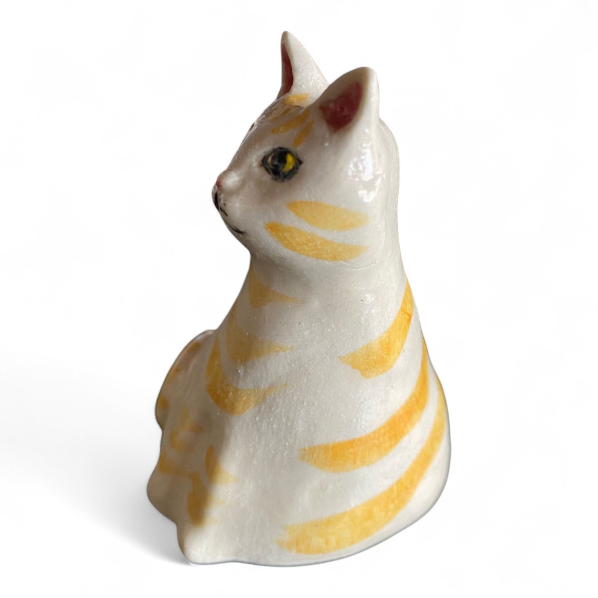 Porcelain cat figurine with orange and white stripes on a white background