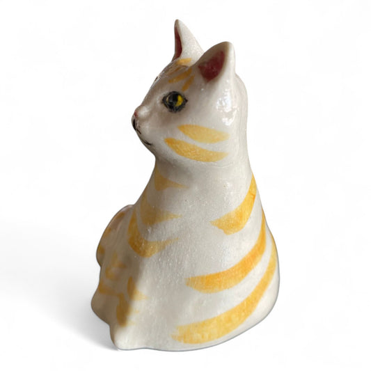 Porcelain cat figurine with orange and white stripes on a white background