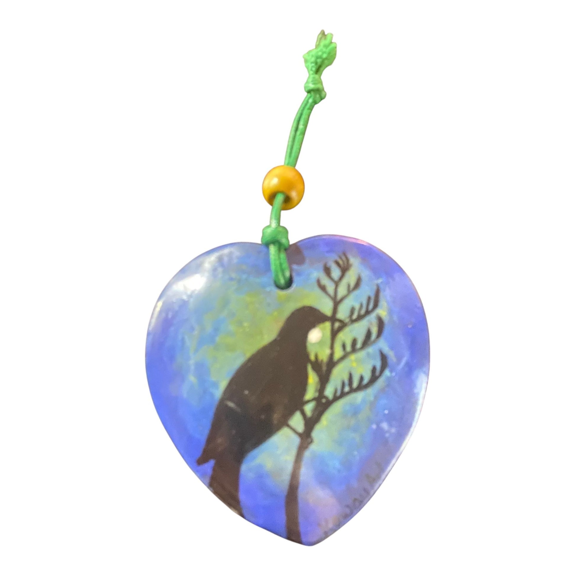 Heart-shaped pendant with Tui bird silhouette design on a white background