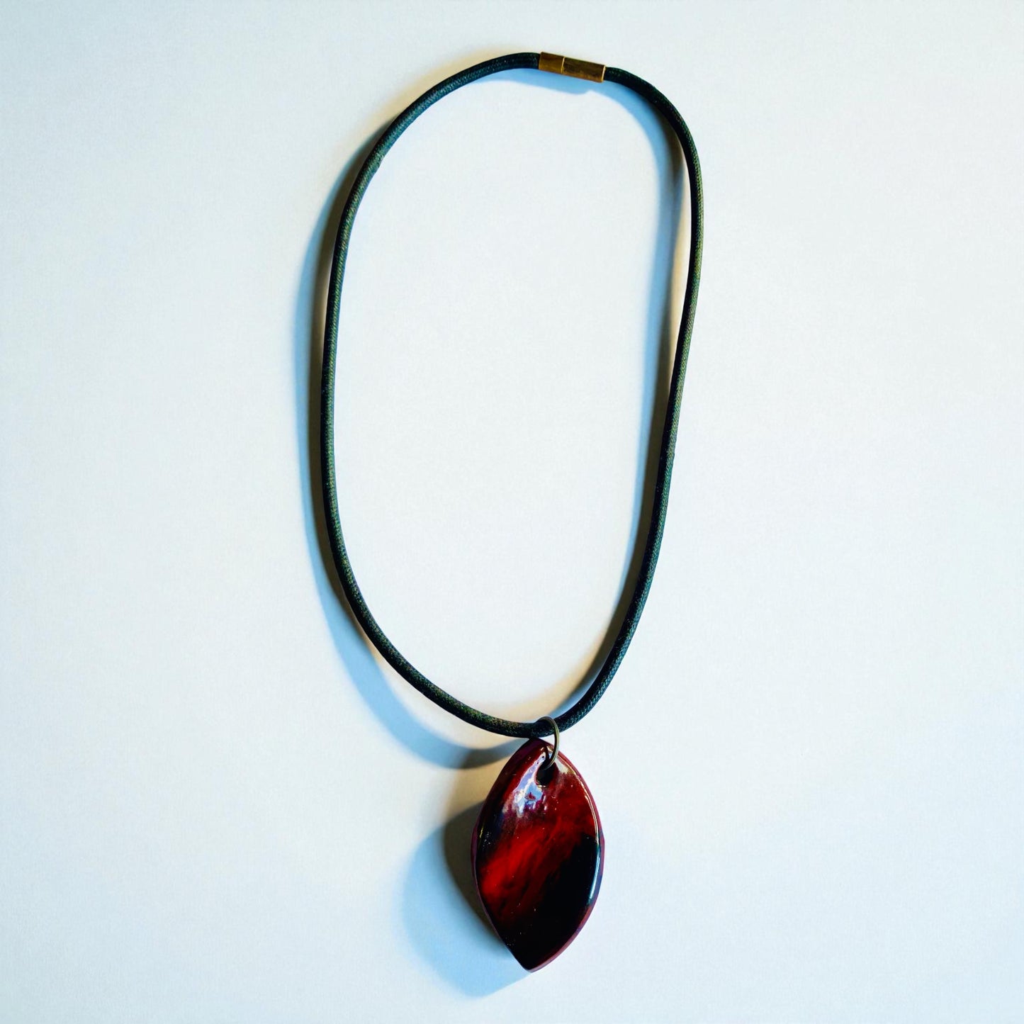Necklace with a red pendant on a light blue background