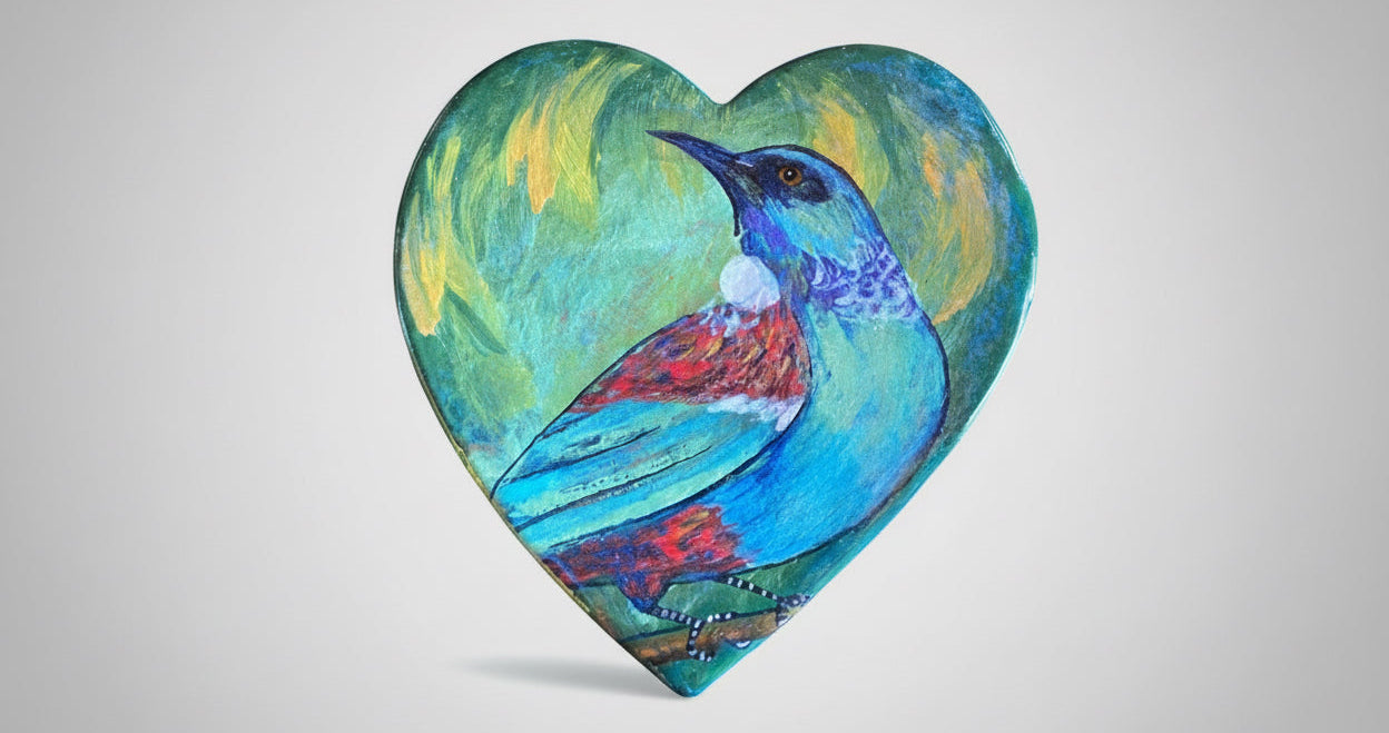 Heart-shaped ceramic wall hanger of a tūī bird