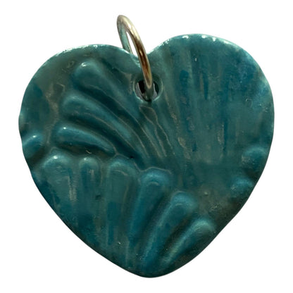 Teal heart-shaped pendant with a textured surface on a white background
